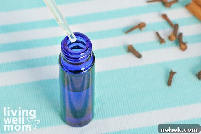5 Essential Oils to Boost Immunity and How to Use Them 7 adding oil to small blue bottle with dropper