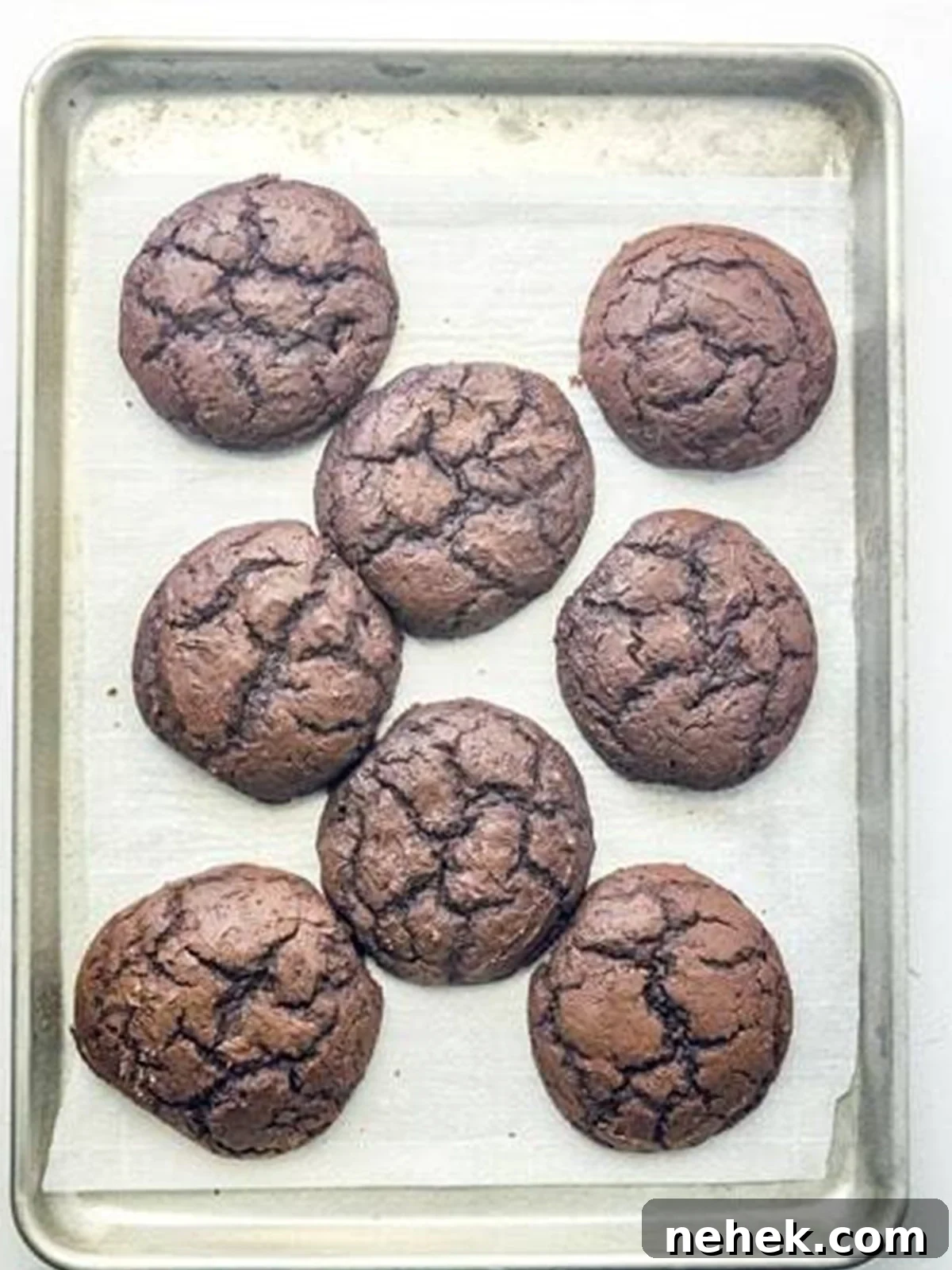 Chocolate Whoopie Pies with Strawberry Frosting Recipe 7 Baked chocolate whoopie pie cookies cooling on a baking sheet.