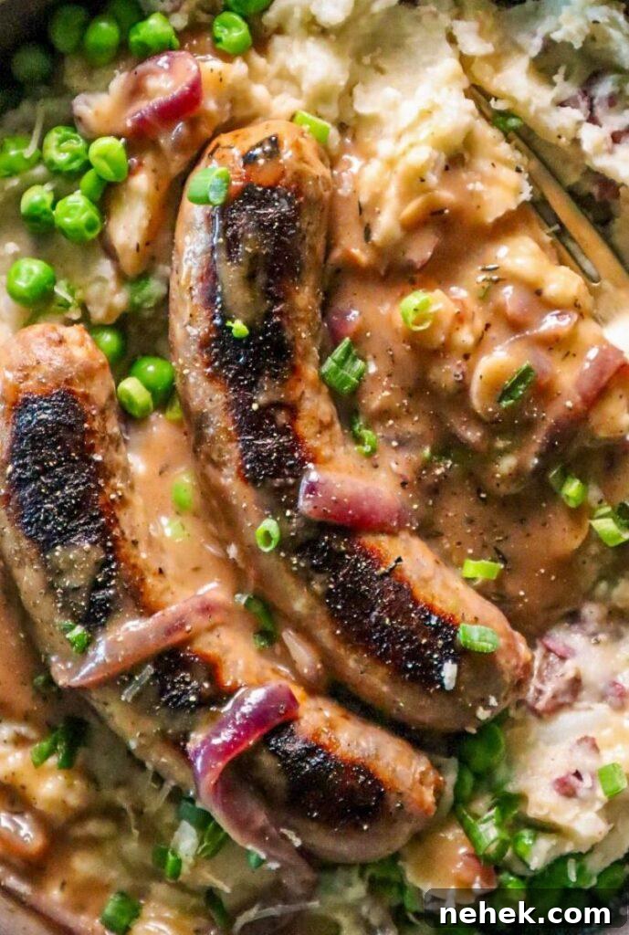 Crispy Bangers with White Cheddar Mash and Garlic-Onion Gravy 5 bangers and white cheddar mash with garlic onion gravy and peas