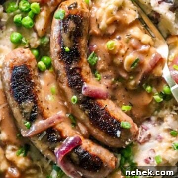 Crispy Bangers with White Cheddar Mash and Garlic-Onion Gravy 6 bangers and white cheddar mash with garlic onion gravy and peas