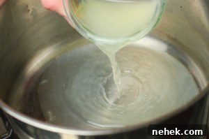 Perfect Lemon Drizzle Cake Recipe — Moist, Zesty Slice 10 Pouring fresh lemon juice into a silver cooking pot