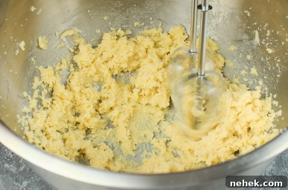 Perfect Lemon Drizzle Cake Recipe — Moist, Zesty Slice 15 Mixing together sugar and butter with a whisk in a silver bowl