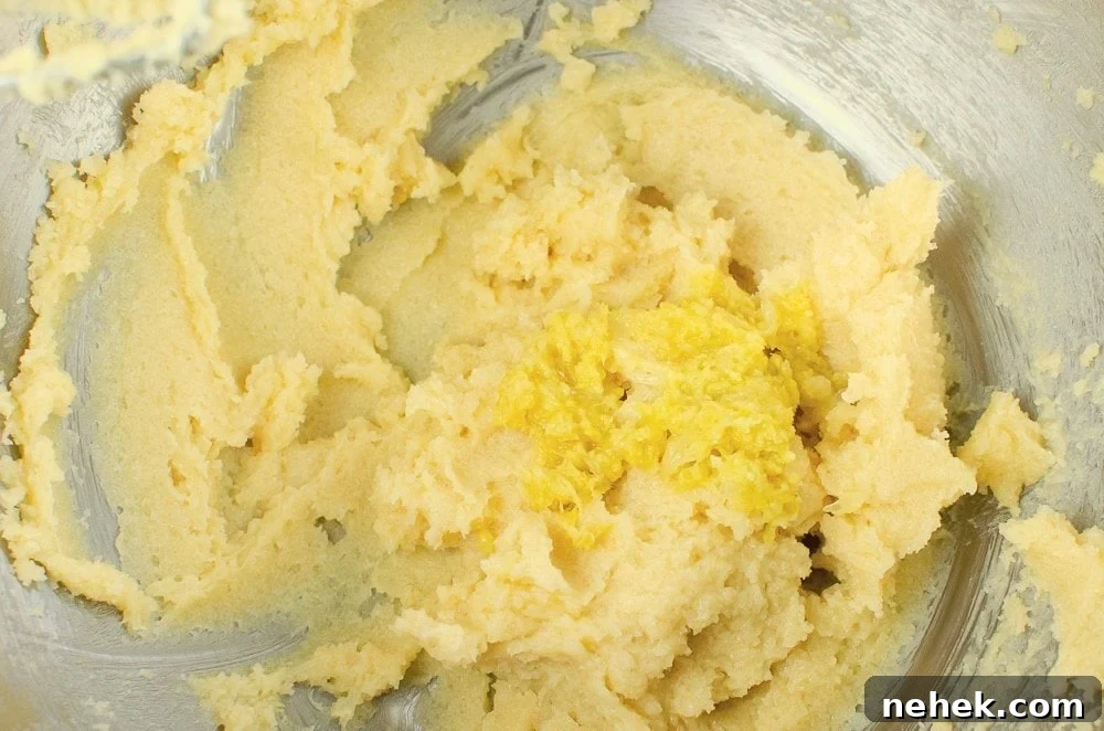 Perfect Lemon Drizzle Cake Recipe — Moist, Zesty Slice 16 Lemon zest added to the butter and sugar mixture in a silver bowl