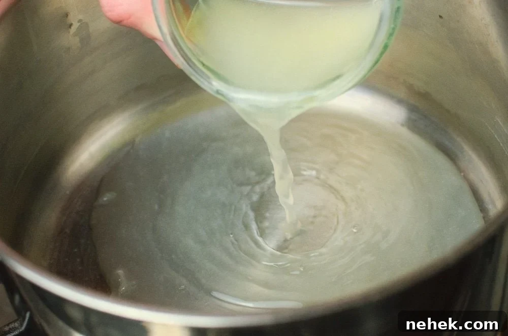 Perfect Lemon Drizzle Cake Recipe — Moist, Zesty Slice 20 Pouring fresh lemon juice into a silver cooking pot