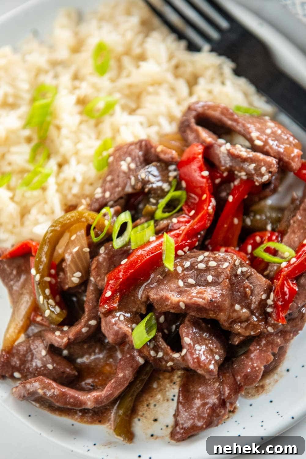 Slow Cooker Pepper Steak: Tender Beef with Peppers & Onions 9 close up of slow cooker pepper steak served on plate