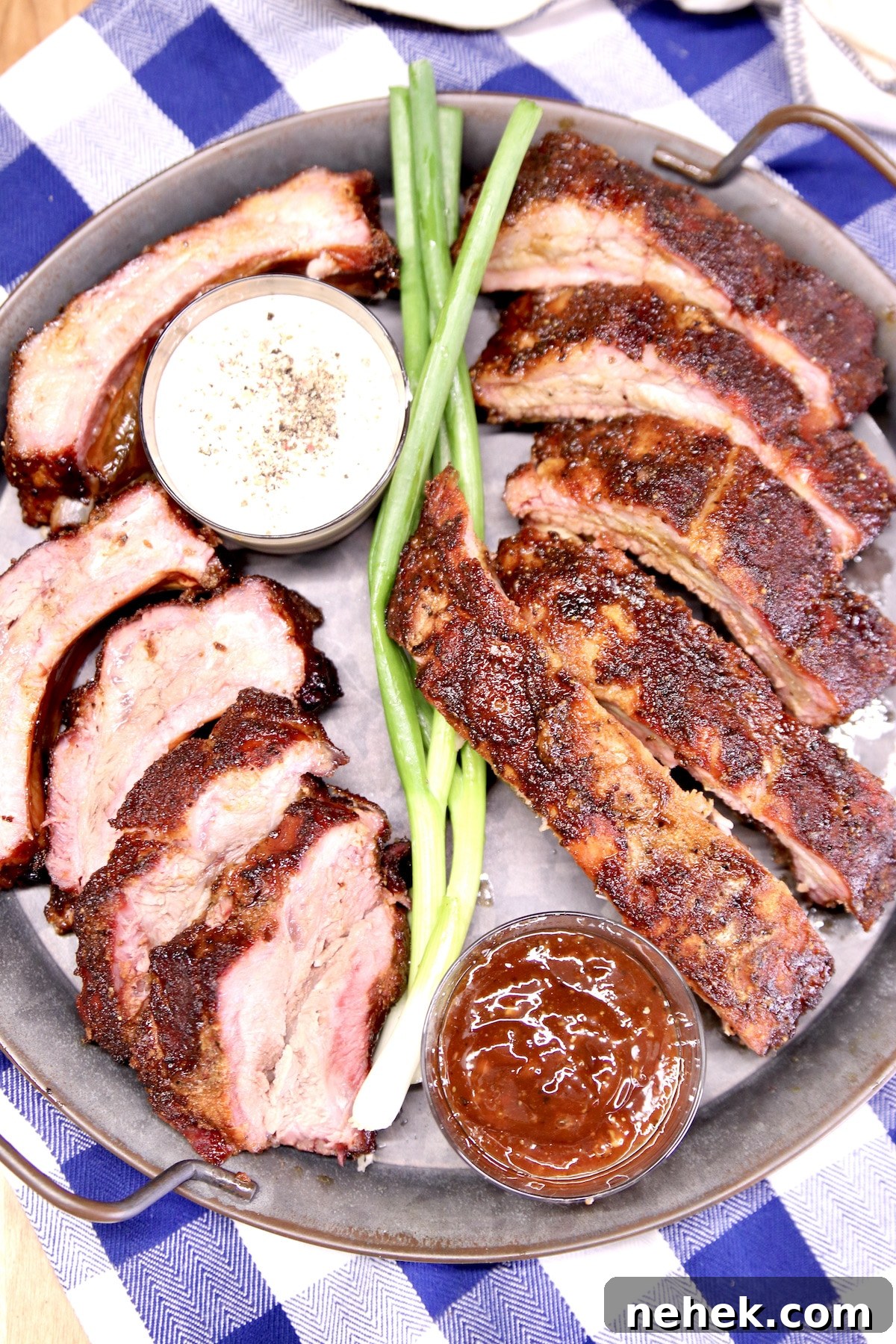 Grilled Baby Back Ribs Platter of baby back ribs with bbq sauce cups and green onions.