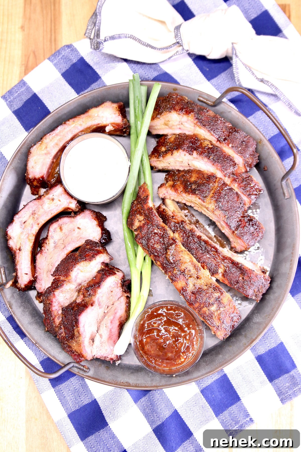 How to grill ribs with dry rub seasoning. Platter of sliced ribs with sauce.
