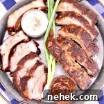 Platter with sliced baby back ribs, green onions, 2 bowls of sauce.