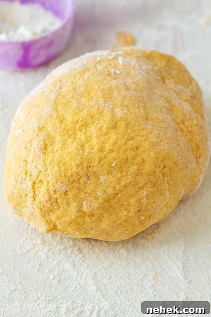 Homestyle Pumpkin Flatbread Recipe for Fall Gatherings 5 Pumpkin flatbread dough ball on a floured board.