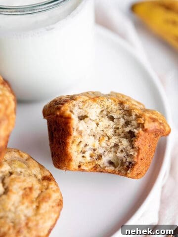 A plate with banana muffins and a glass of milk with a banana.