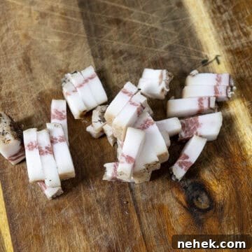 Authentic Bucatini Amatriciana Recipe 5 Chopped guanciale in strips on a cutting board.