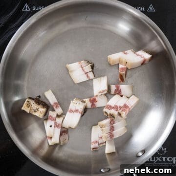 Authentic Bucatini Amatriciana Recipe 6 Guanciale in a cold pan about to fry.