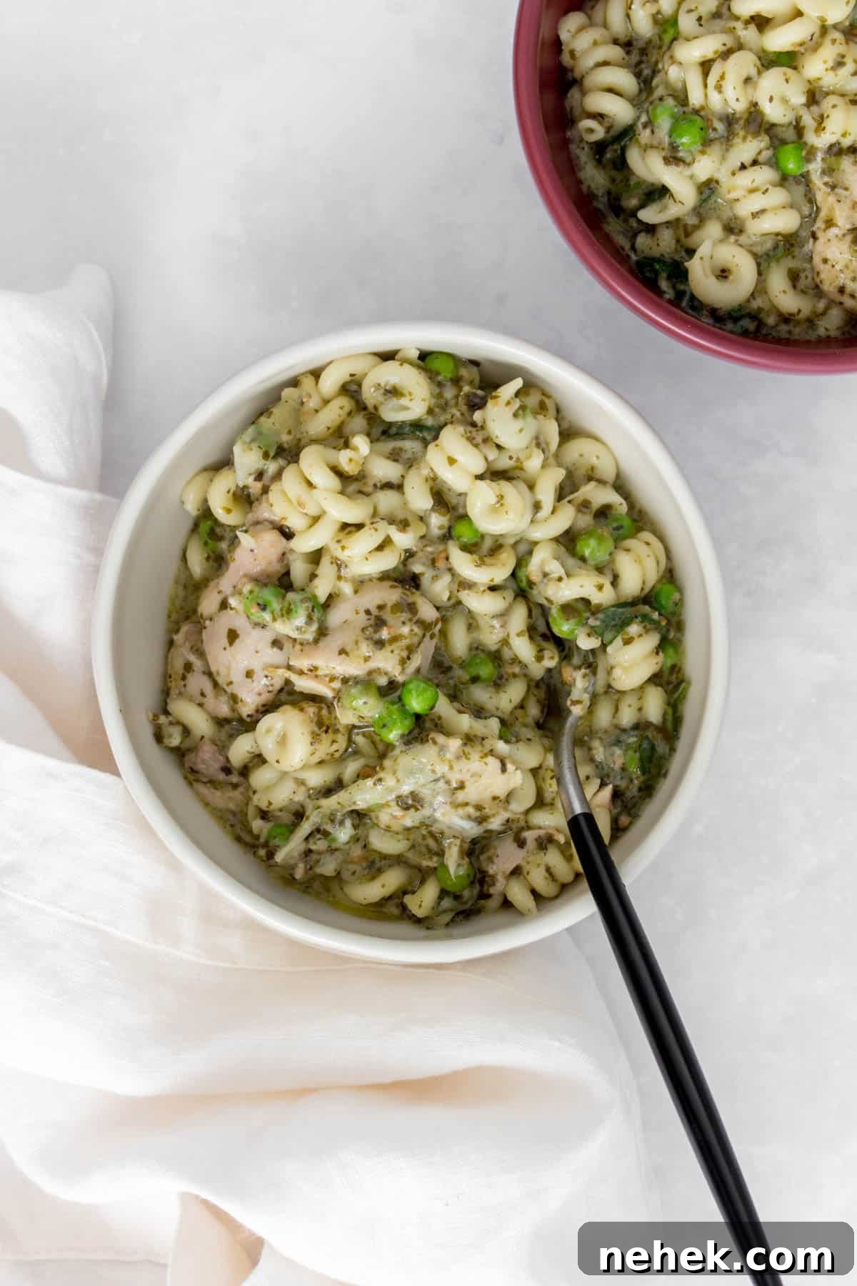 Creamy Instant Pot Chicken Pesto Pasta 12 Bowl with chicken pesto pasta with a fork.