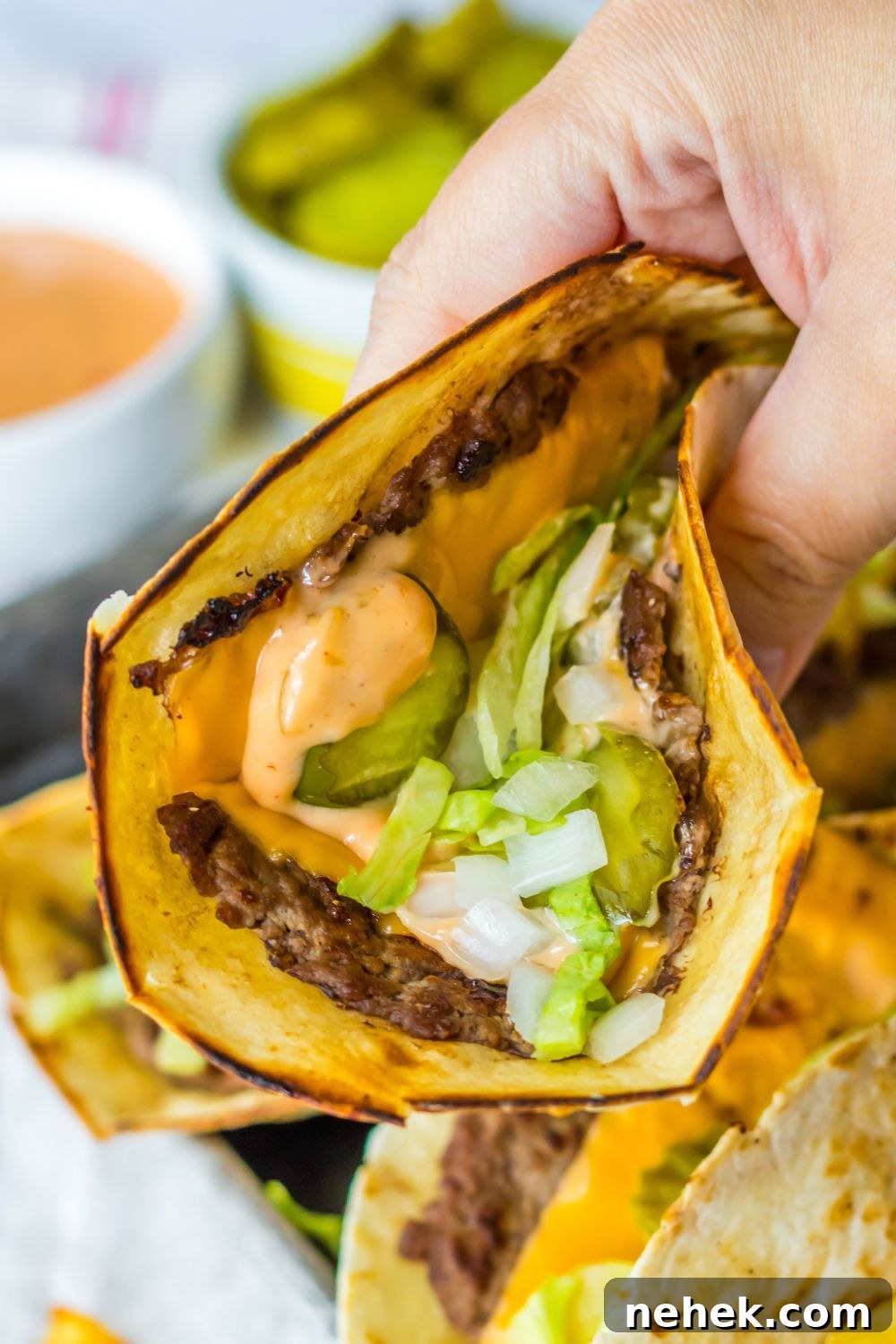 Big Mac Smash Tacos Recipe: Crispy Beef Tacos with Special Sauce 11 holding smash big mac taco in hand