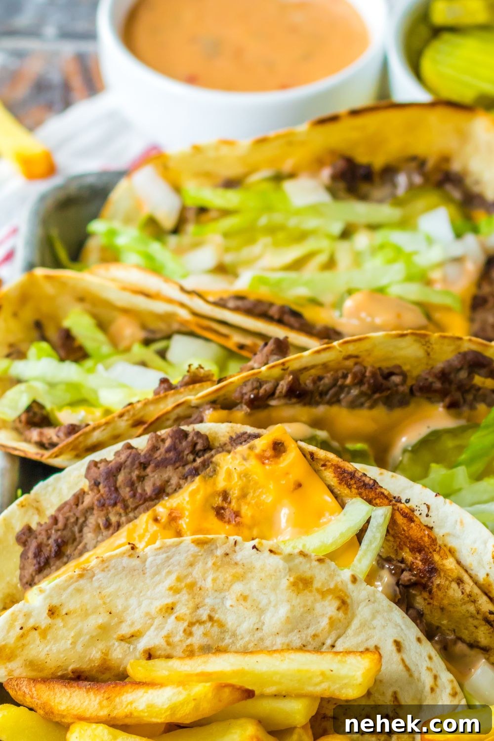 Big Mac Smash Tacos Recipe: Crispy Beef Tacos with Special Sauce 15 easy big mac smash tacos on a plate with sacue behind it in a container