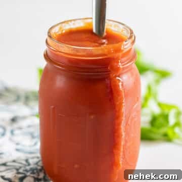 Homemade Sugar-Free Marinara Sauce 10 A jar of homemade marinara sauce with a spoon in it and some sauce dripping down the front.