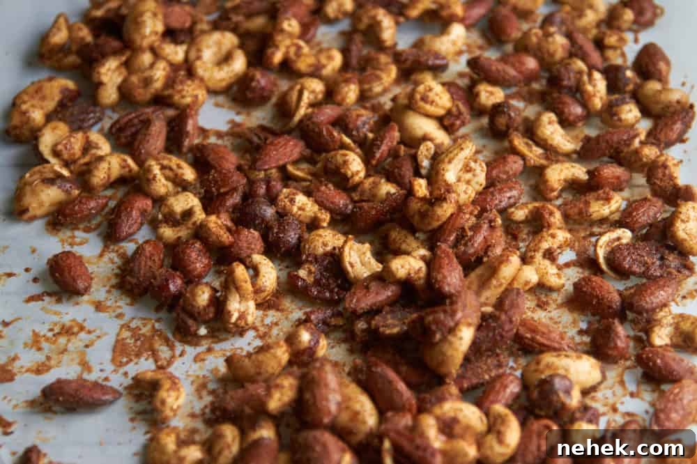Sweet and Spiced Roasted Nuts 6 Spiced mixed nuts on white parchment paper.